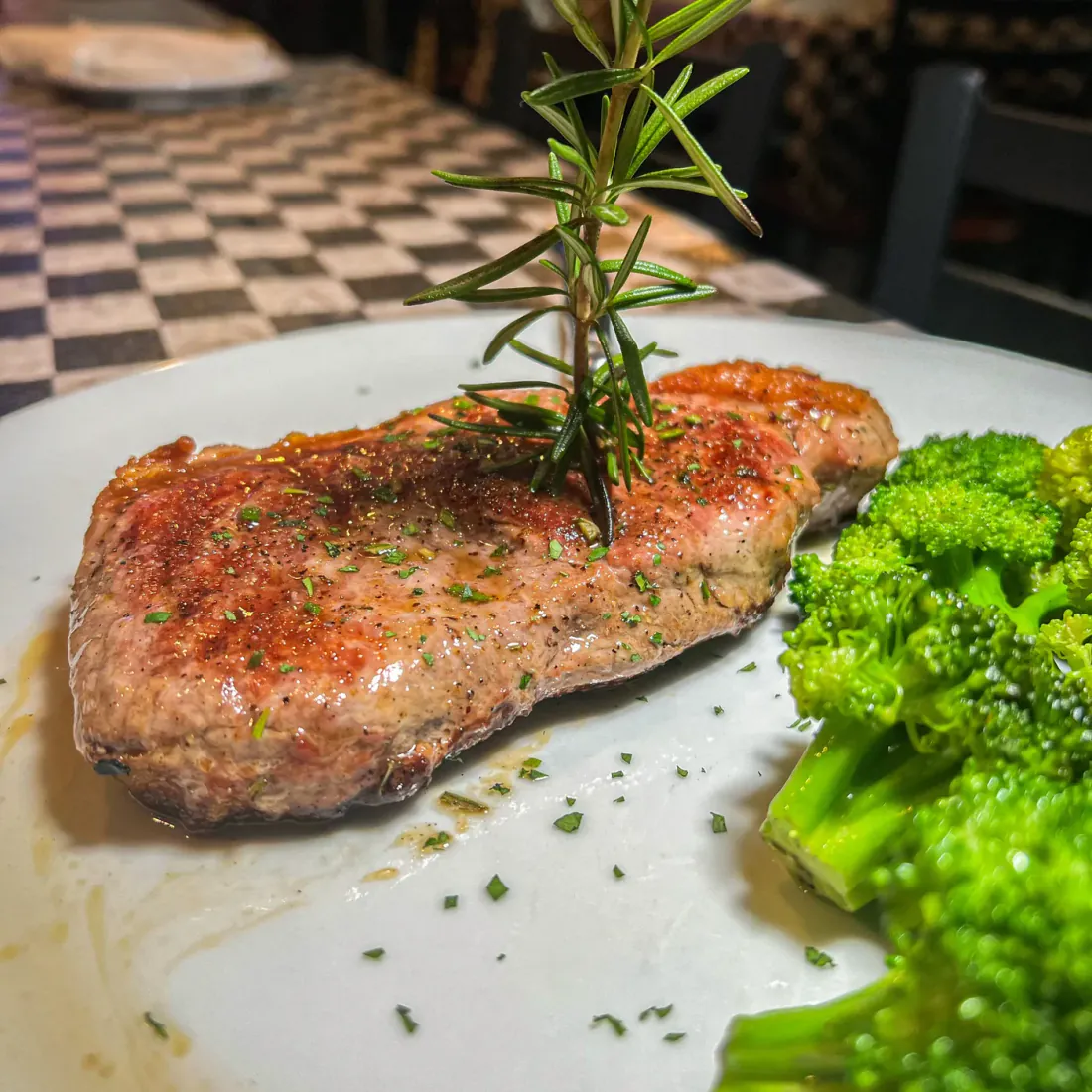 A New York strip steak with broccoli and rosemary